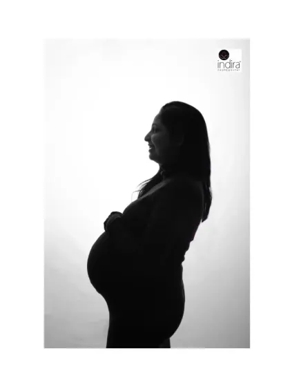 A smiling profile silhouette of the mother-to-be, capturing her joy and the beautiful curve of her pregnancy.