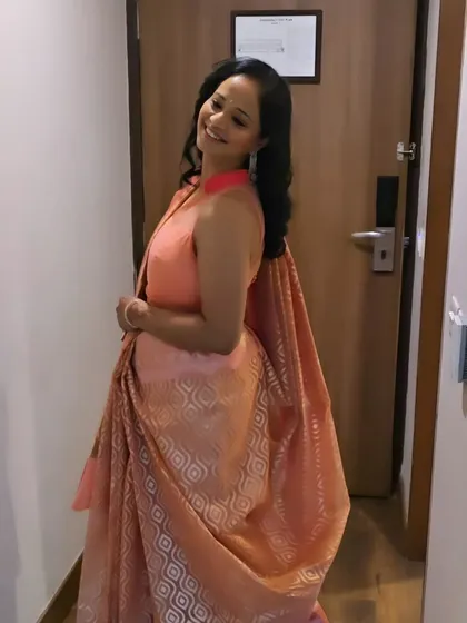 The final look, a happy client in her beautiful peach saree. The soft makeup and classic hairstyle create a timeless and graceful appearance.