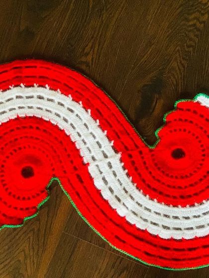A top-down view of the red and white spiral Christmas runner, showing its unique shape.