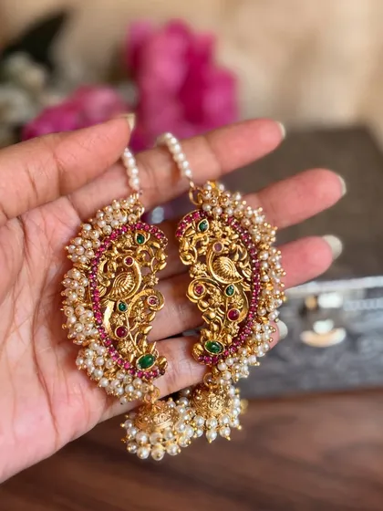 A slightly different angle of the peacock Karnaphool, showing the intricate carving and the jhumka drop.