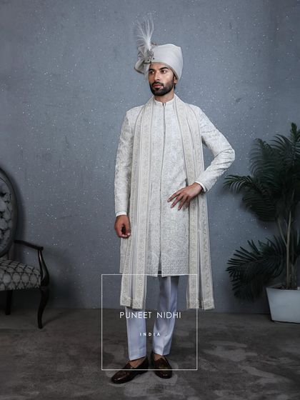 An ivory sherwani where every bead and stitch carries the warmth of family and culture. Paired with a stole and crowned with a sarpech, it becomes an emotion to be remembered.