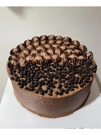 A classic Dutch Truffle cake decorated with chocolate chips and piped frosting. A simple, no-fuss option for pure chocolate lovers.
