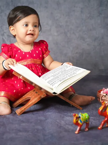 A young scholar reading from a Sanskrit book. We create unique themes to celebrate Indian culture and heritage.