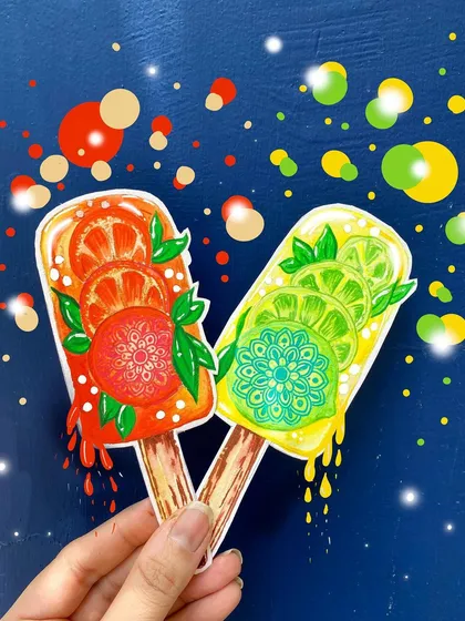 Summer vibes! These two popsicle cutouts are decorated with citrus slices and a small, detailed mandala in the center of each one, blending food art with intricate patterns.