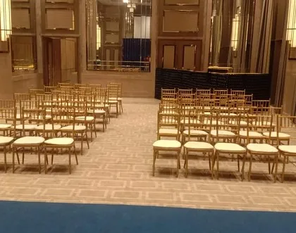 A clean and elegant seating arrangement for a reception or formal event inside a modern hotel banquet hall. We ensure that the guest seating is organized and complements the overall decor of the venue.