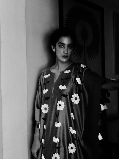 A black and white portrait for Baavli, focusing on the intricate floral details of the dress. The monochrome tones add a timeless, classic feel.
