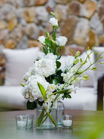 A simple, elegant bouquet of white hydrangeas and orchids sits on a coffee table in our lounge area. This detail shows how we carry our aesthetic through every space.