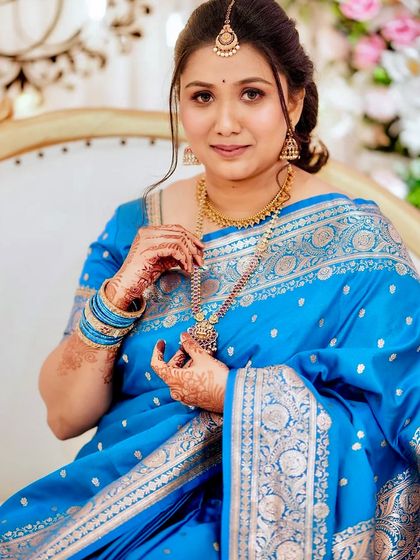 A stunning engagement look for Sushmita in a vibrant blue saree. The makeup is soft and elegant, with a focus on her eyes.