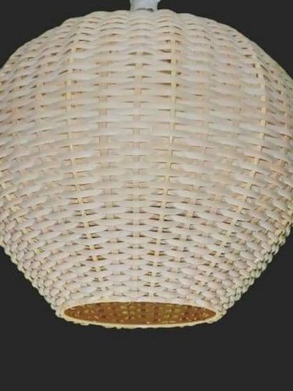 A close-up of our white woven rattan pendant light. The clean, spherical shape and tight weave offer a modern and fresh take on natural lighting, perfect for minimalist or coastal-themed interiors.