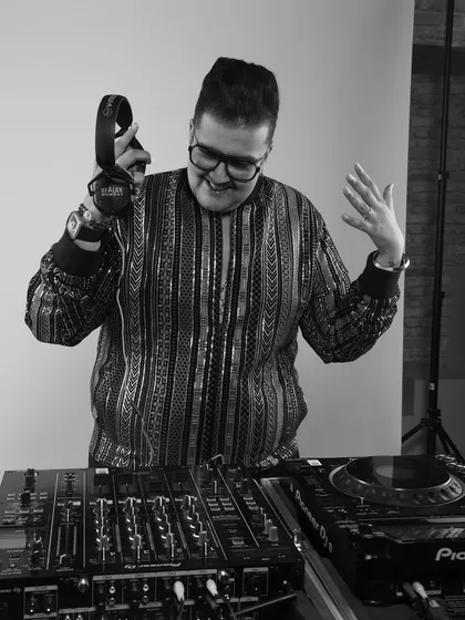 A black and white shot of me at the decks, smiling. This captures the pure joy I find in performing and sharing music with people.