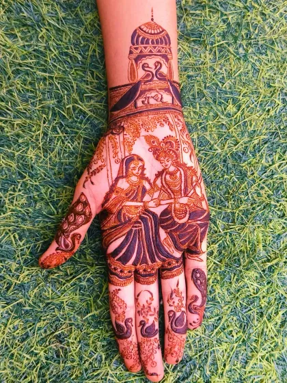A clear and beautiful Radha Krishna portrait on the palm against a green background. The design is perfect for festivals like Janmashtami or for a bridal theme.