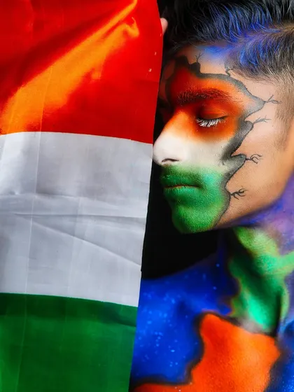 A profile shot of the patriotic makeup, with the Indian flag held alongside, creating a powerful and symbolic image.