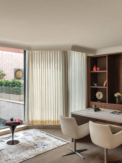 This spacious director's cabin in 'The Layered Office' is tailored to the user's requirements, with a large desk and a private seating area. The curved wall of windows offers a prime view of the landscaped terrace.