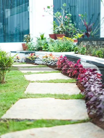 This garden path uses simple stone slabs set into the lawn, leading the eye through the space and past colorful border plantings.