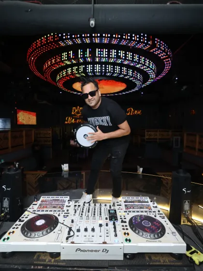 Here I am in my element at Bombay Cocktail Bar, ready to drop the beat. With my Pioneer DJ setup and my Darbuka drum, I'm prepared to deliver a unique set that blends electronic music with live tribal rhythms.