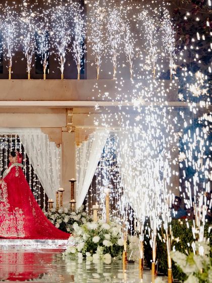 A final, spectacular display of pyrotechnics framing the bride on the mirrored aisle. This is the kind of unforgettable, cinematic moment we love to create.