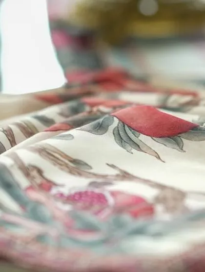 Detail of a custom-printed napkin, showcasing the delicate floral and bird pattern that was central to the 'दाड़म ka Bageecha' visual identity.