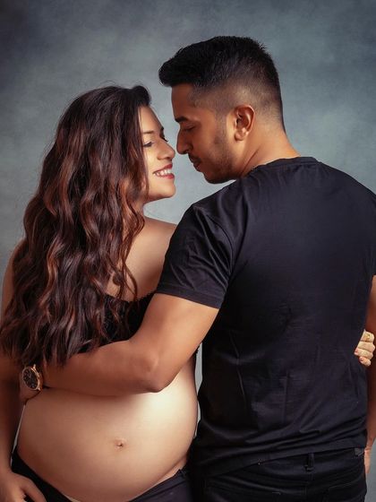 The look of love. This intimate, bare-bump shot against a simple grey backdrop is a powerful and beautiful way to capture your connection.