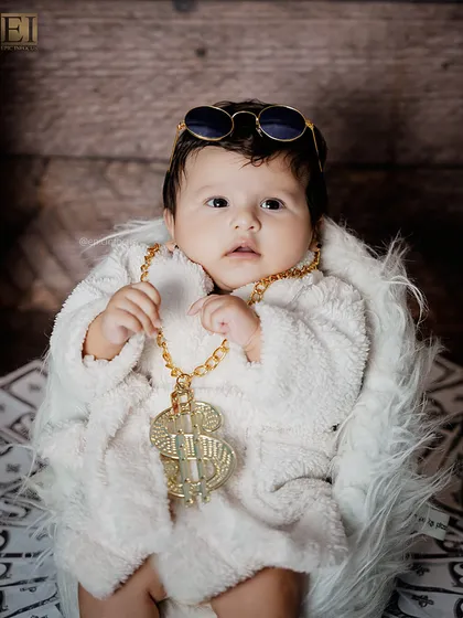 A close-up shot of our little millionaire, complete with a gold chain and sunglasses. It's a playful and memorable theme that always gets a laugh.