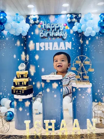 This is a glimpse into our 'Twinkle Twinkle Little Star' theme, where we create a dreamy celestial world. The setup features a custom backdrop, themed pedestals for the cake, and a multi-layered balloon arch in shades of blue, silver, and white to bring the night sky indoors.