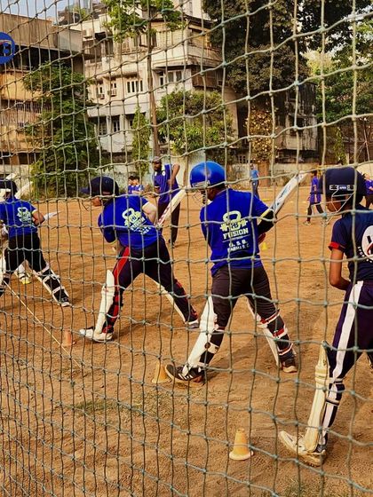 Batting practice in the nets is where technique is perfected. This action shot shows several young players practicing their swings simultaneously, highlighting the structured nature of our training sessions.