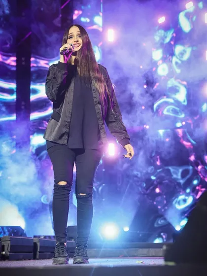Lana Rose performing amidst a haze of stage smoke, with a beautifully abstract digital background. This is a great example of capturing the mood of a modern concert.