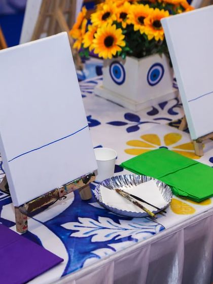 A close-up of the canvas painting setup, with mini easels, paints, and brushes ready for each guest.