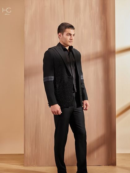 A full-length view of the textured cocktail jacket, showing how it pairs with simple black trousers to let the jacket remain the hero of the outfit.