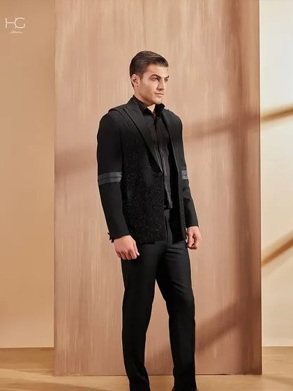 A full-length view of the textured cocktail jacket, showing how it pairs with simple black trousers to let the jacket remain the hero of the outfit.