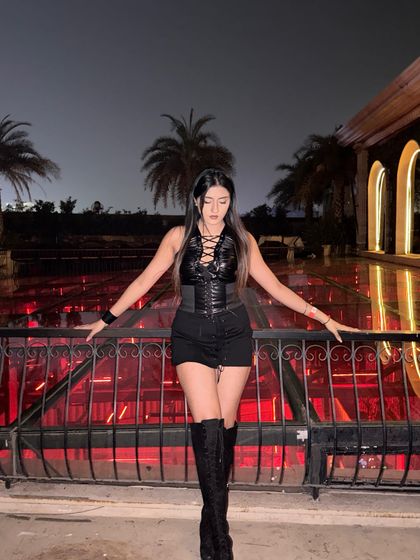 A powerful pose against a dramatic red-lit background.