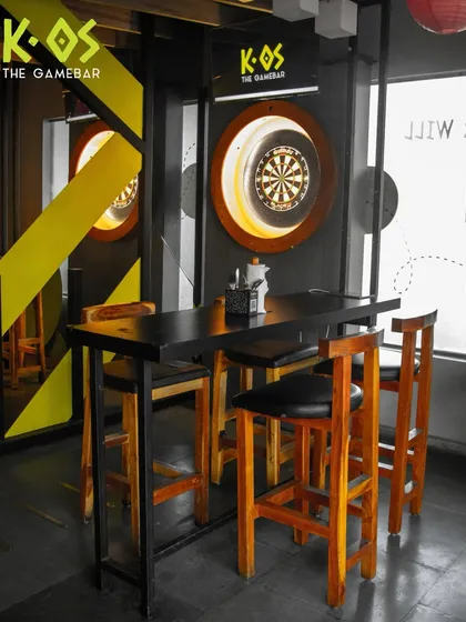 A high-top table right next to the dartboards, perfect for enjoying a drink while you wait for your turn to play.