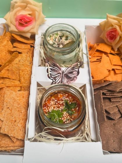 The perfect gift for snack lovers: my Cracker Box. It includes a variety of artisanal crackers like peri-peri, amaranth, and ragi, served with Mexican salsa and a spinach cream cheese dip.