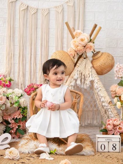 A wide shot of the complete boho first birthday setup. The teepee, macrame hanging, and floral baskets create a stunning and cohesive scene.