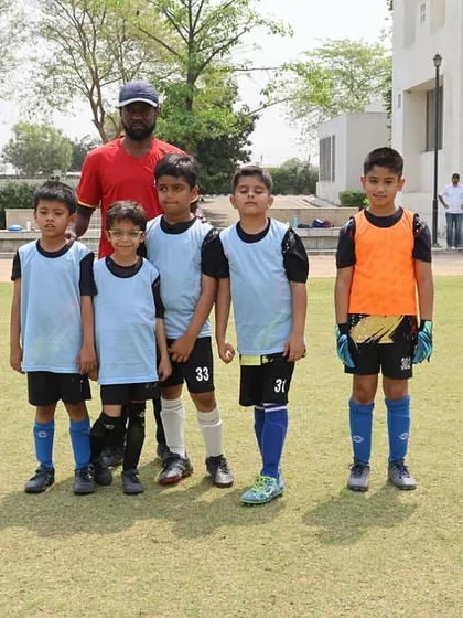 A team photo with their coach during the DFA League. We foster a strong sense of unity and team identity, with coaches acting as mentors.