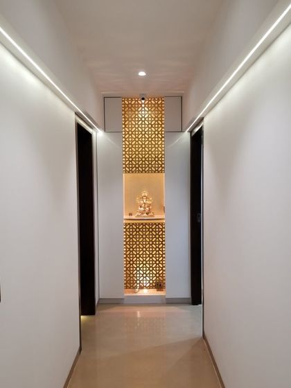 Sometimes, beauty lies in simplicity. This corridor design is clean and minimalist, leading to a beautifully designed temple niche at the end. The intricate jali screen is backlit to create a warm and divine glow.