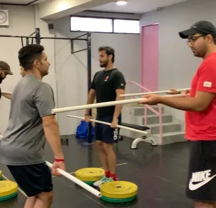 Our Olympic Weightlifting seminars start from the absolute basics. Here you can see a coach guiding athletes through fundamental positions using PVC pipes, focusing on mobility and technique before adding any weight.