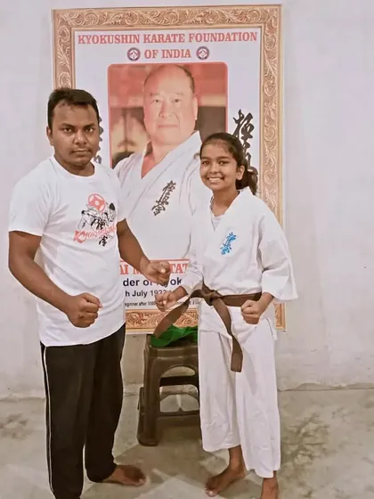 Awarding a new brown belt. She has shown great improvement and dedication to reach this level.