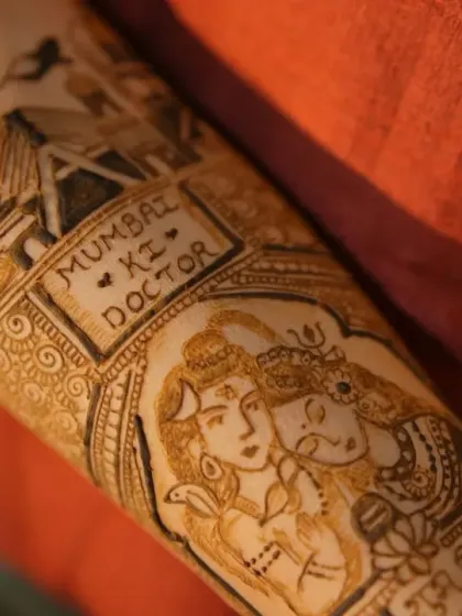 A detailed close-up of a bridal arm design featuring a Shiv-Parvati portrait and the phrase 'Mumbai ki Doctor', showcasing how we can blend divine blessings with personal stories.