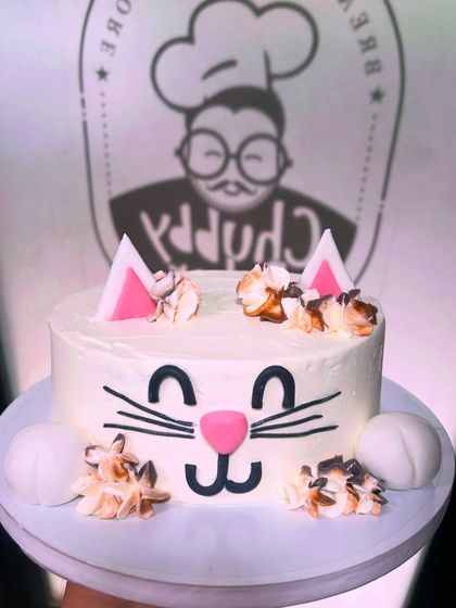 This cute cat cake is basically our spirit animal at the bakery. A simple white cake with a sweet hand-piped face, fondant ears, and fluffy buttercream details.