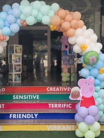 A Peppa Pig balloon decoration on the colorful steps at the entrance of Oxford Kids.
