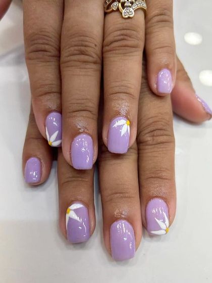 A closer look at the delicate, hand-painted floral art on this short lilac manicure.