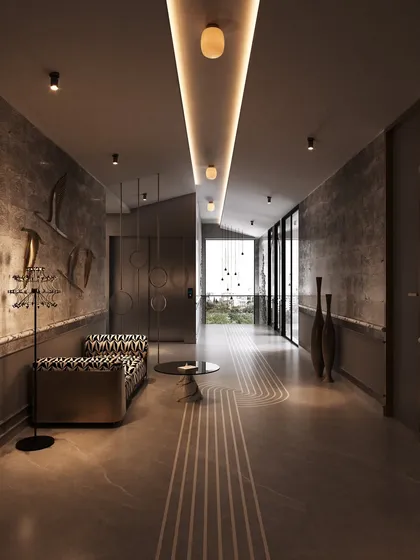 The play of light and shadow in this corridor highlights the rich textures of the walls and the metallic sheen of the art. We use lighting to create ambiance and draw attention to the carefully curated details that define our spaces.