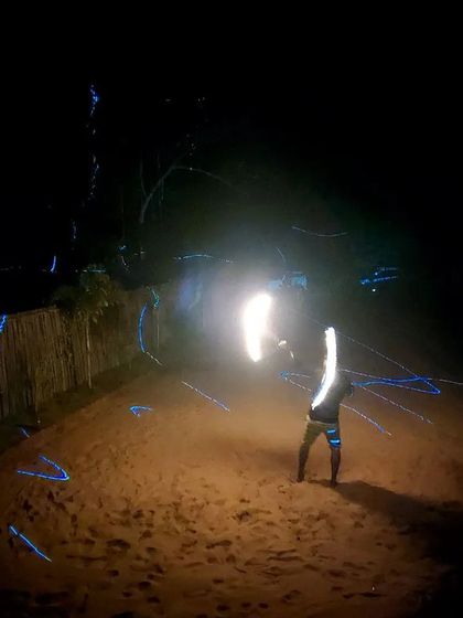 A fire dancer on the beach at night, part of the vibrant nightlife we experience on our Gokarna trips.