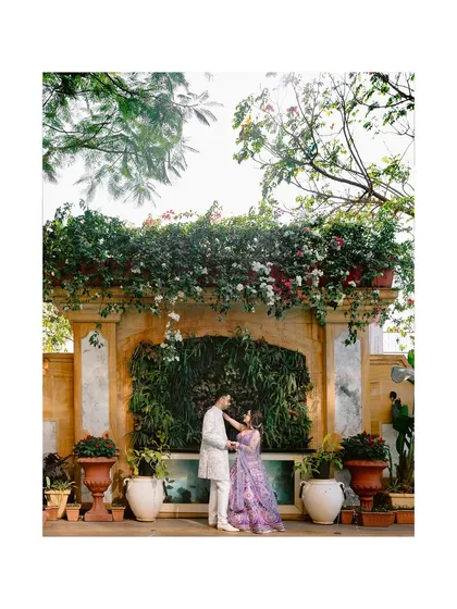 A romantic portrait of the couple against a beautiful green wall, a moment of intimacy amidst their Haldi celebrations.