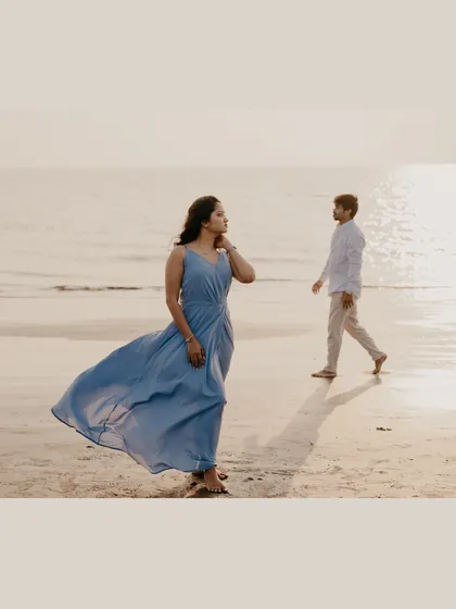 A candid shot of the couple on the beach, creating a sense of story and quiet contemplation by the ocean.
