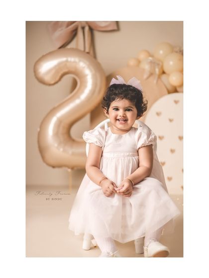 Two years of adorable wrapped in a bow. This sweet girl's second birthday portrait is elegant and timeless with a neutral color palette.