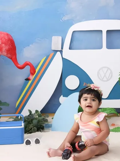 Sandy toes and a happy heart. Sitting in the sand, this baby is enjoying her studio beach day. The vibrant colors and fun props make for a cheerful and unique portrait.