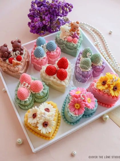 My collection of heart-shaped cake candles is perfect for making birthdays and baby showers extra special. This tray shows the variety of designs, from teddy bears and strawberries to delicate flowers.