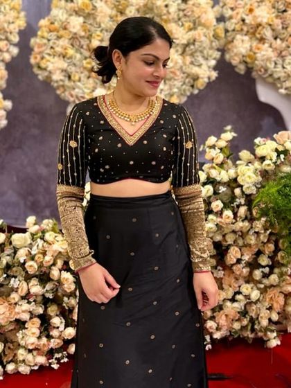 The gorgeous Amulya in a custom black lehenga. The blouse features long sleeves with intricate gold embroidery for a dramatic and elegant look.