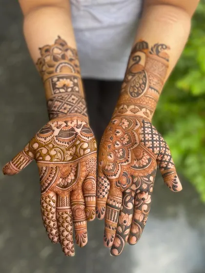 A clear view of the palms, adorned with a mix of peacock and mandala designs.